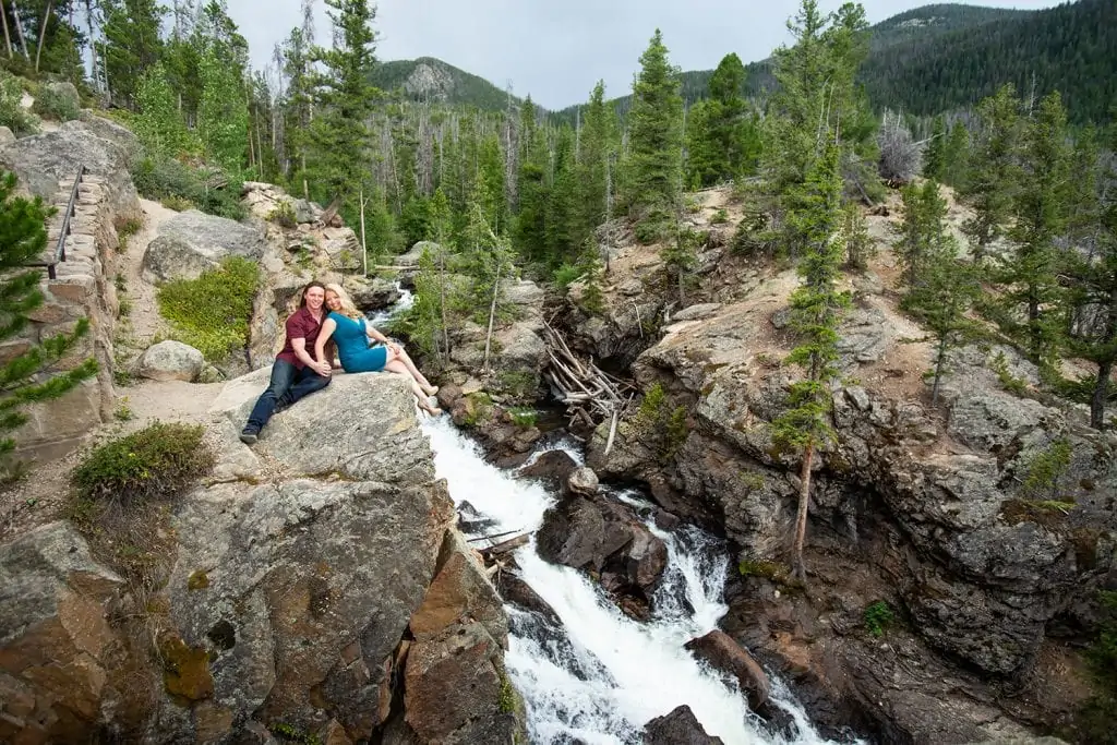 An engagement photo at adams falls in rocky mountain national park.