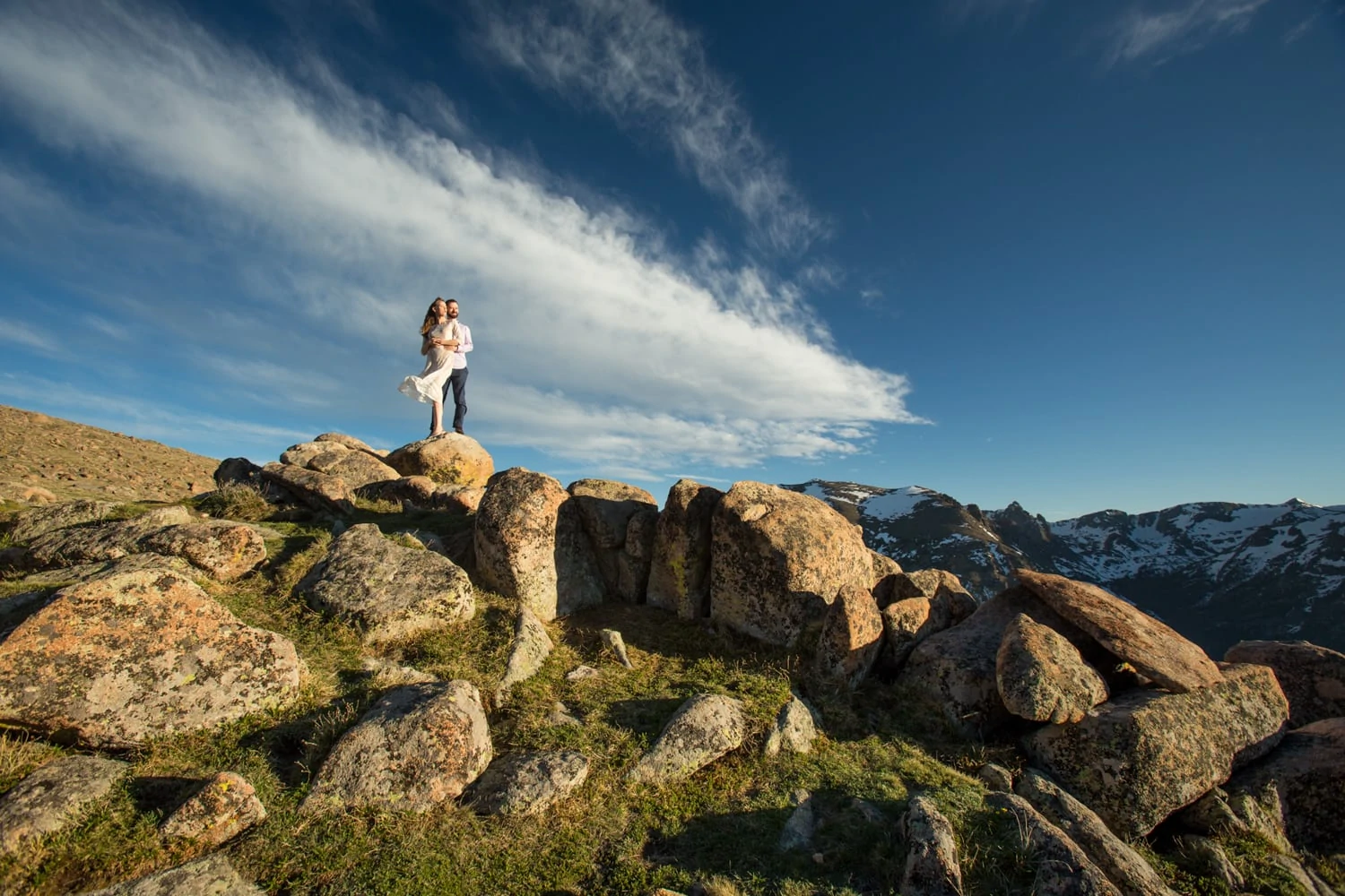 Wind blows around the engagement photographer as they shoot on trail ridge road in rocky mountain national park.