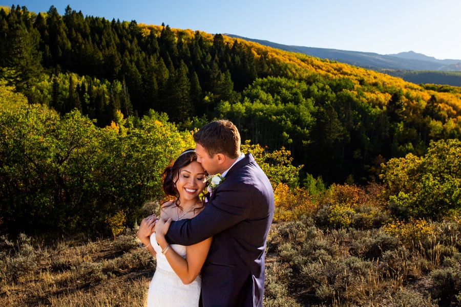 An elopement couple hugs in Aspen, Colorado in fall.
