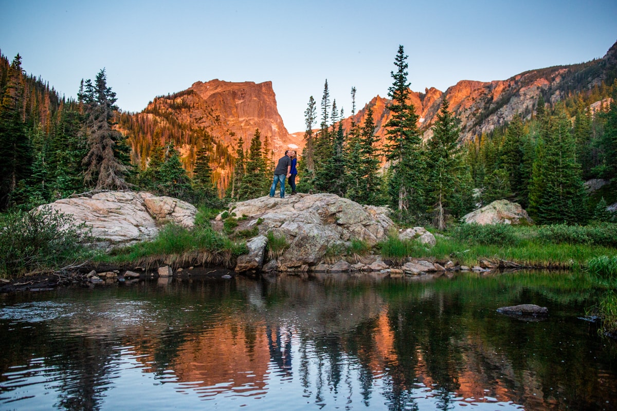 And engagement photo at dream lake at sunrise in rocky mountain national park.