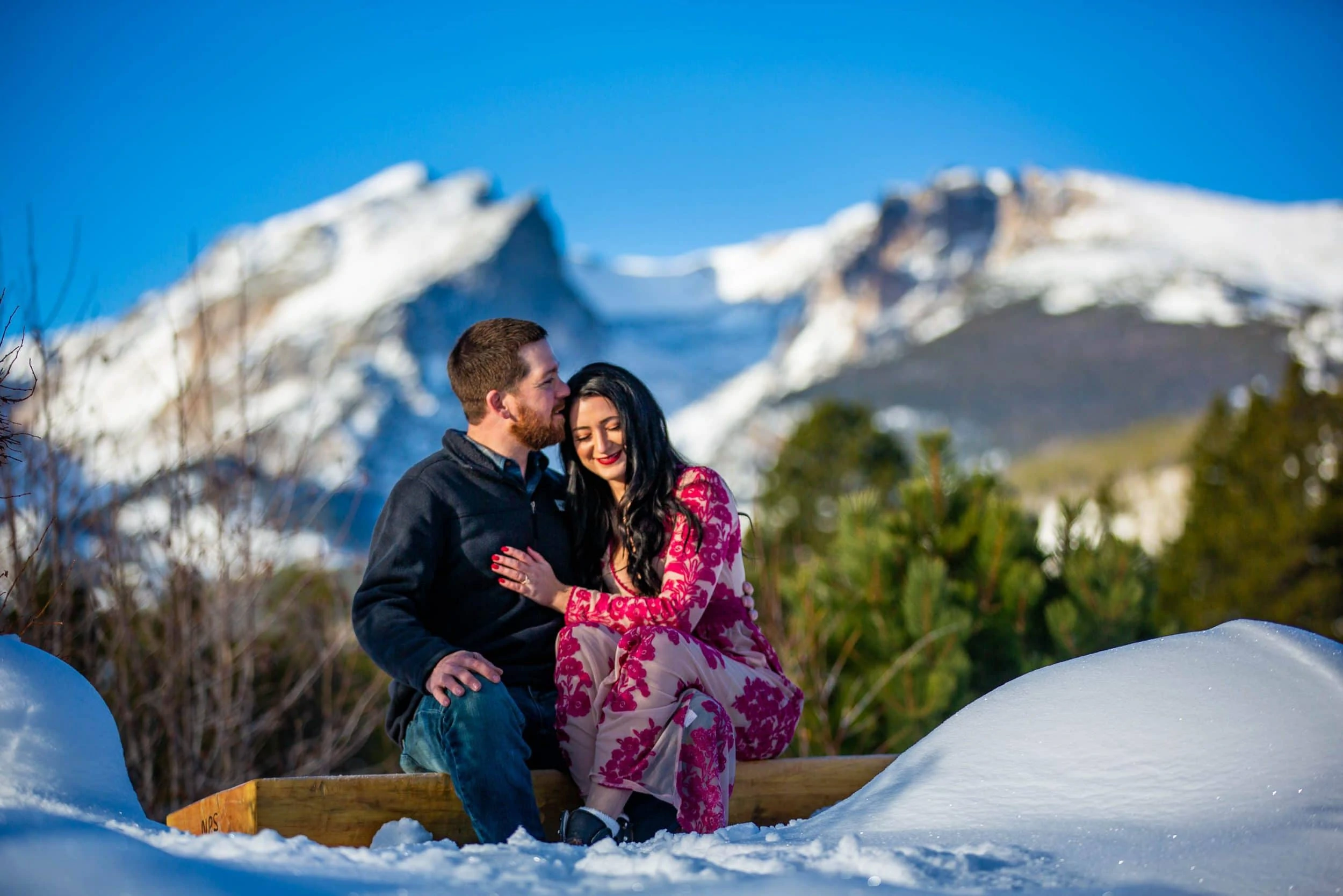 An engagement photo in winter at Sprague Lake in Rocky Mountain National Park.