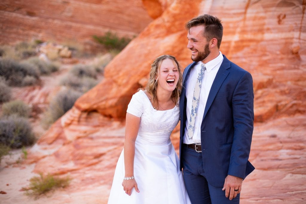 A wedding couple laughs together in their valley of fire elopement location.