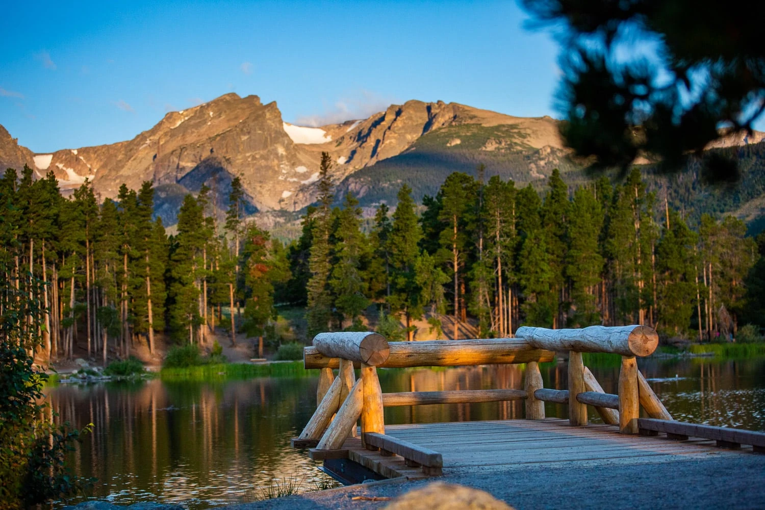 First light covers the mountain range behind the ada accessible elopement location called Sprague Lake in Rocky Mountain National Park, Colorado.