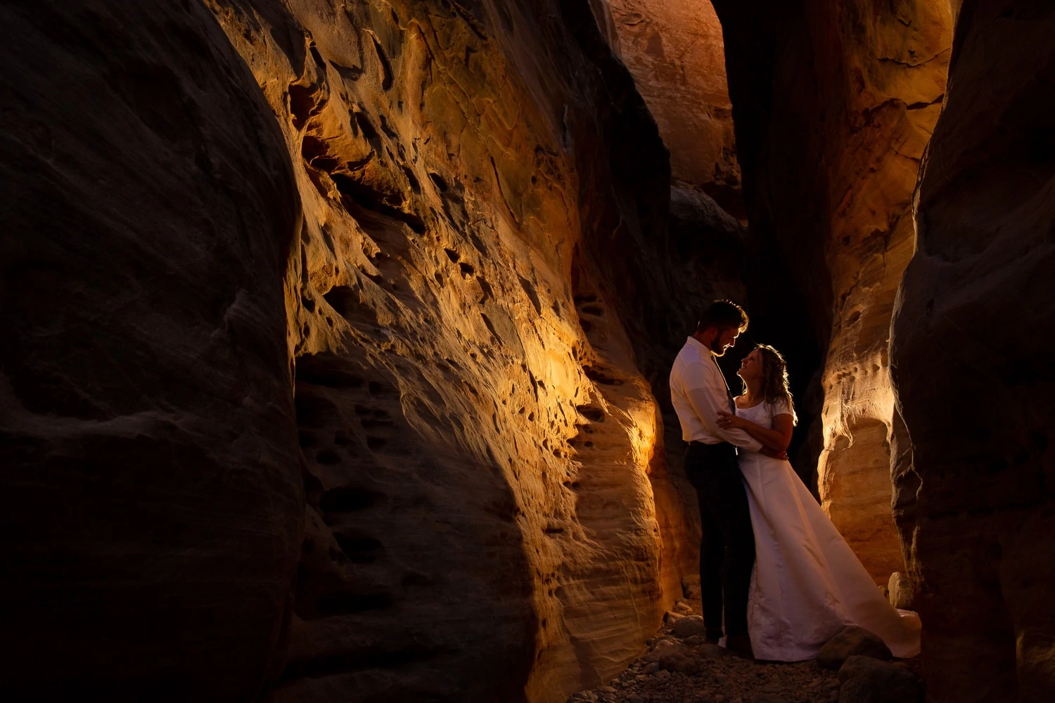 An adventurous wedding couple is photographed in a slot canyon.
