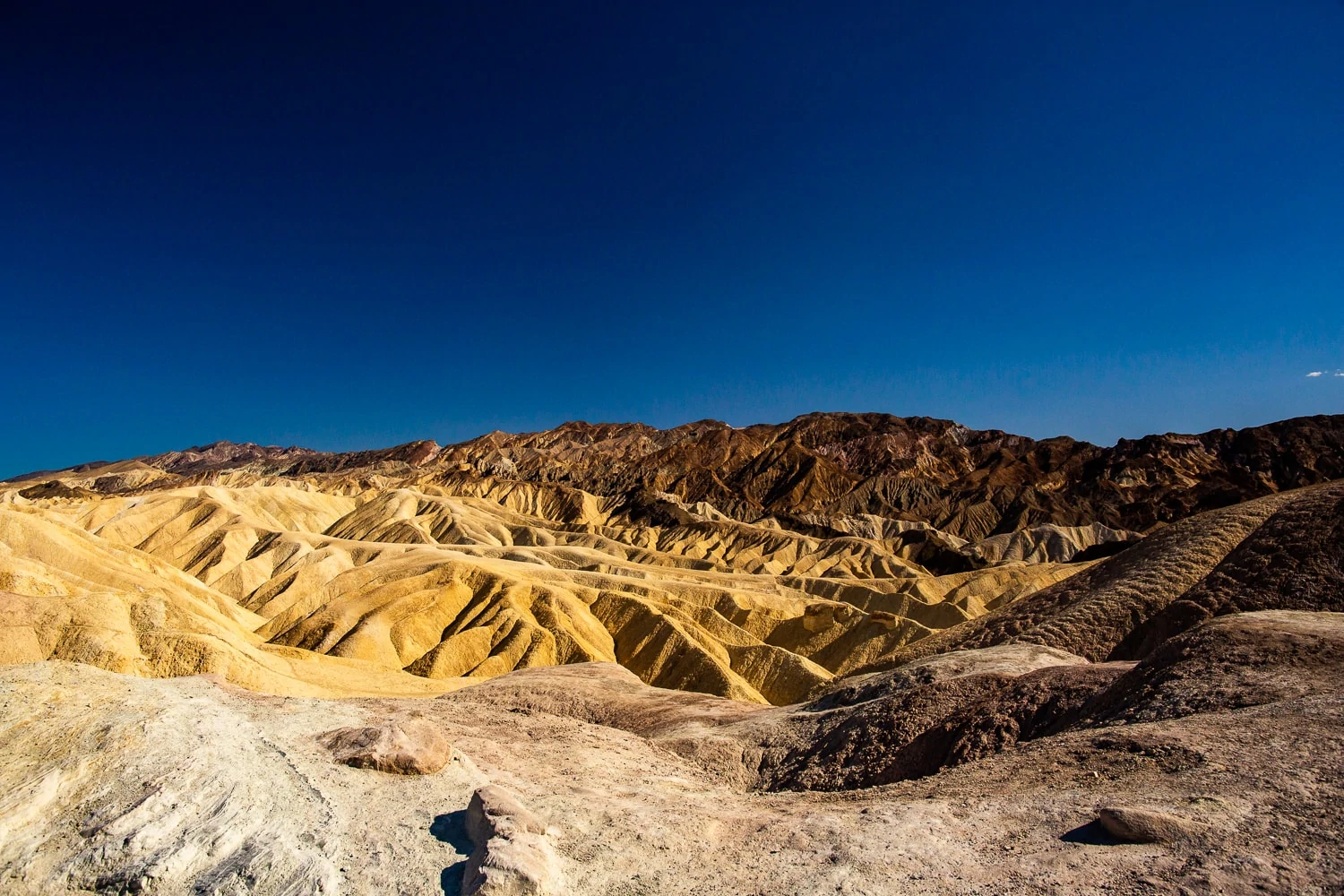A colorful photos of yellow rolling hills at Zabriskie point in Death Valley