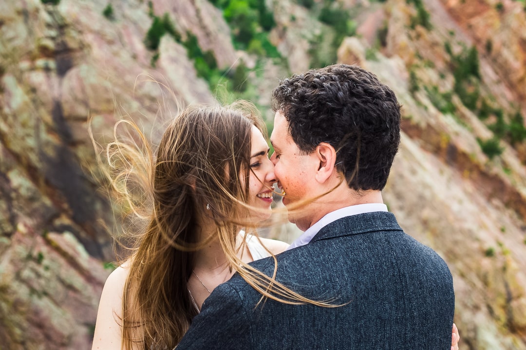 A bride's hair is blown by the wind on a mountainside in Boulder.