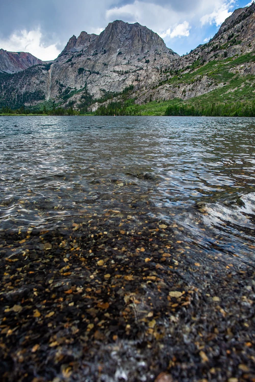A vertical photo of Silver Lake showing the mountains and clear water over a gravel bottom.