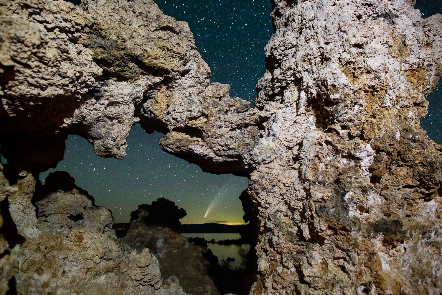 The Neowise Comet is visible through a Tufa formation at Mono Lake.