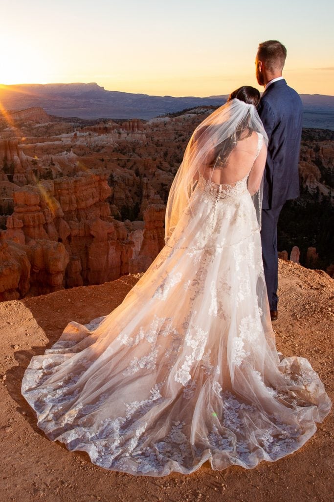 A wedding couple watches the sun come up at their elopement in bryce canyon national park.