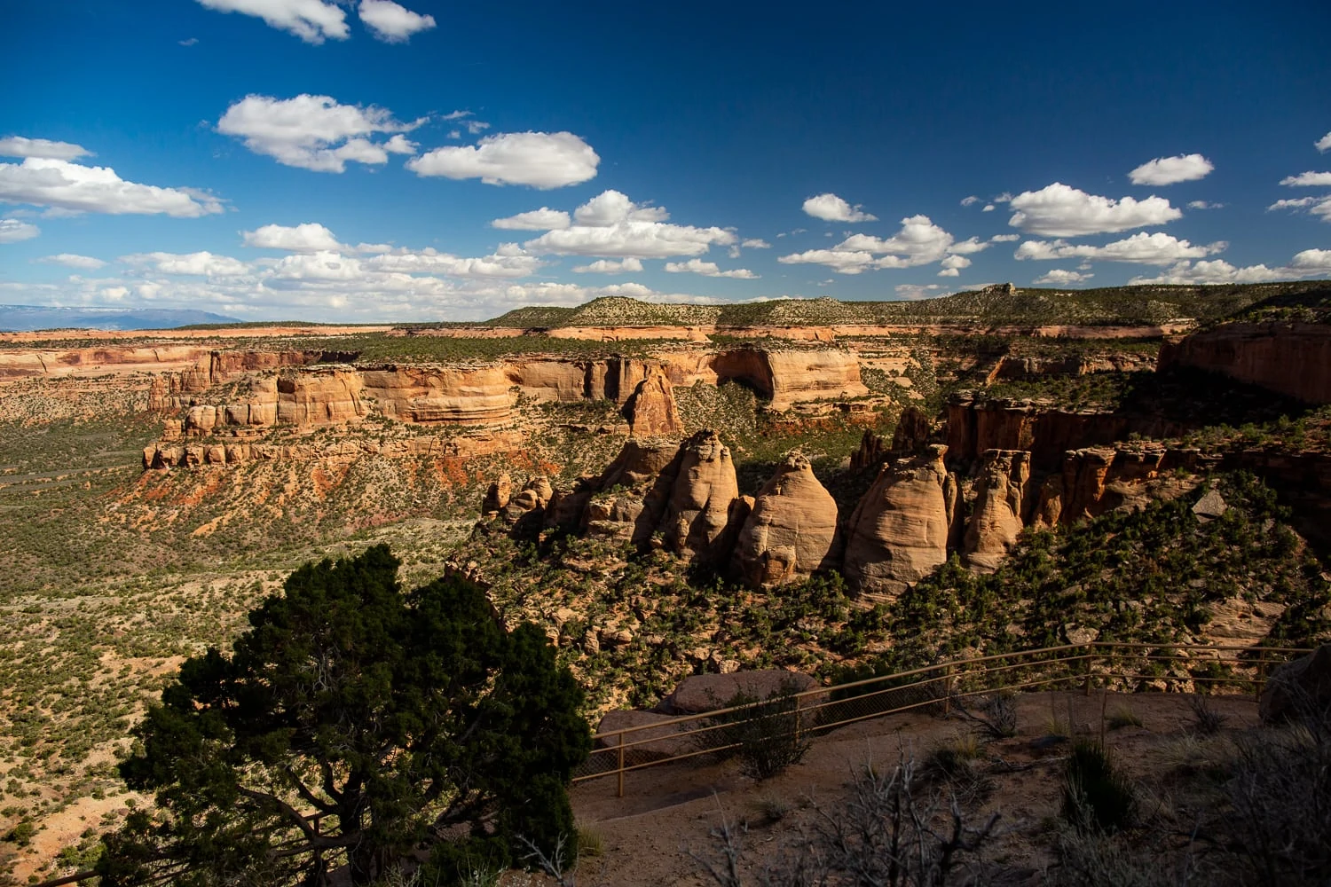 Blue sky over the red canyon of Colorado National Monument with the Coke Ovens rock formations in the foreground.