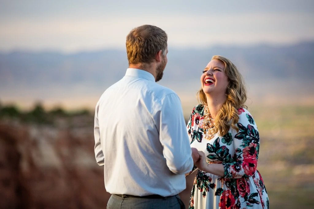 The bride throws her head back in laughter in this candid elopement ceremony photo by Colorado National Monument photographer Lucy Schultz.
