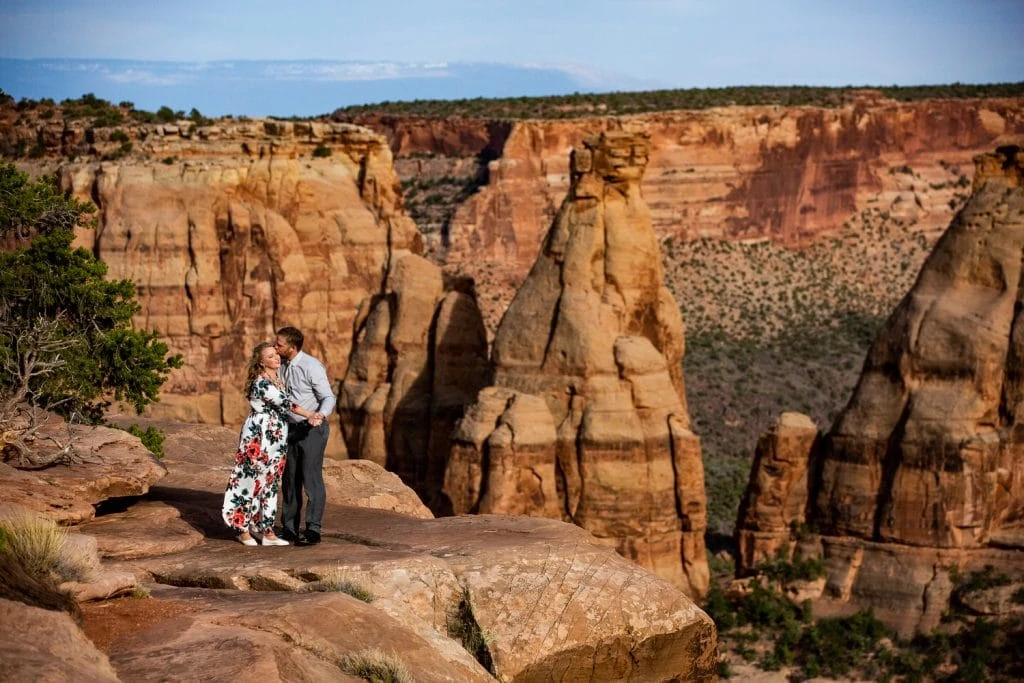 An elopement couple hugs on the sunny rim of Colorado National Monument in Western colorado.