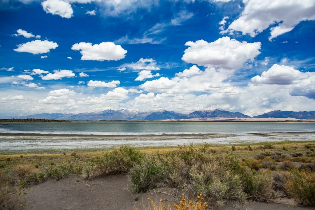 San Luis lake near Alamosa, Colorado on a sunny day with white puffy clouds.