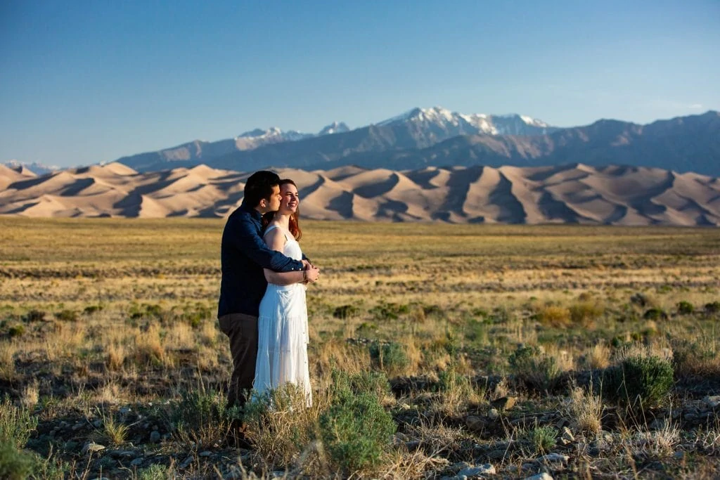 A groom holds his bride during their vow renewal at Great Sand Dunes National Park.