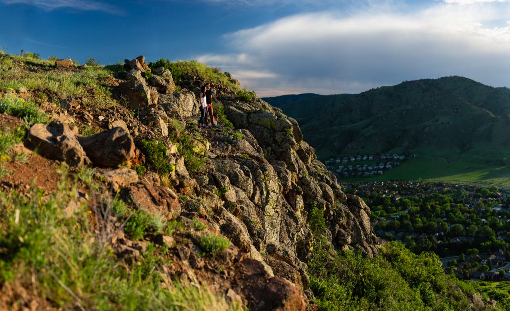 An engaged couple look out over Golden, Colorado from North Table Mountain.