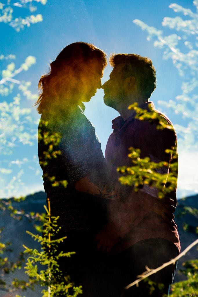 A double exposure of a rainbow over a gay couple's silhouettes.