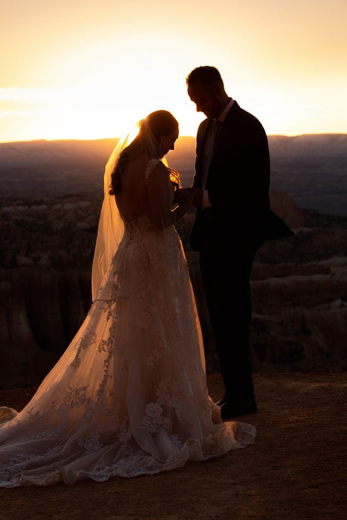 A silhouette of a bride and groom saying their vows at sunrise in Bryce Canyon.