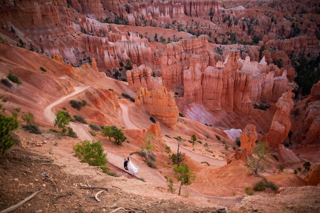 An elopement couple walks through the trails in Bryce Canyon national park.