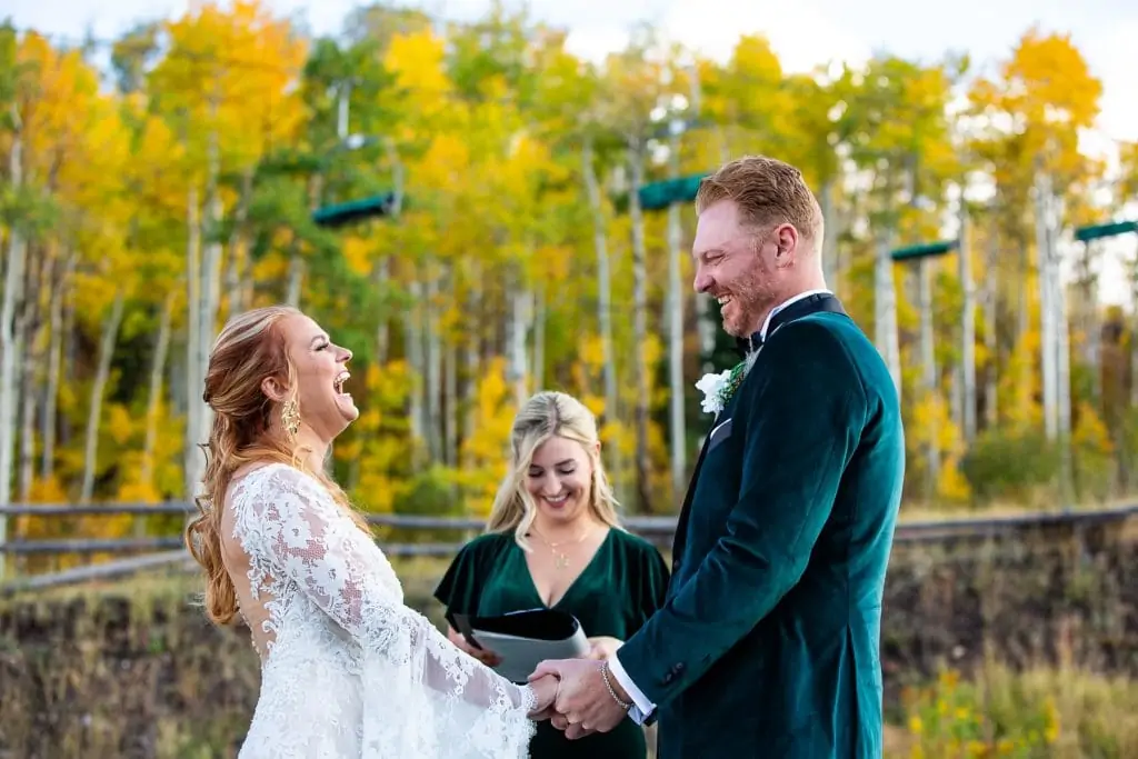 An Aspen, Colorado elopement ceremony under a ski lift with fall leaves behind them.