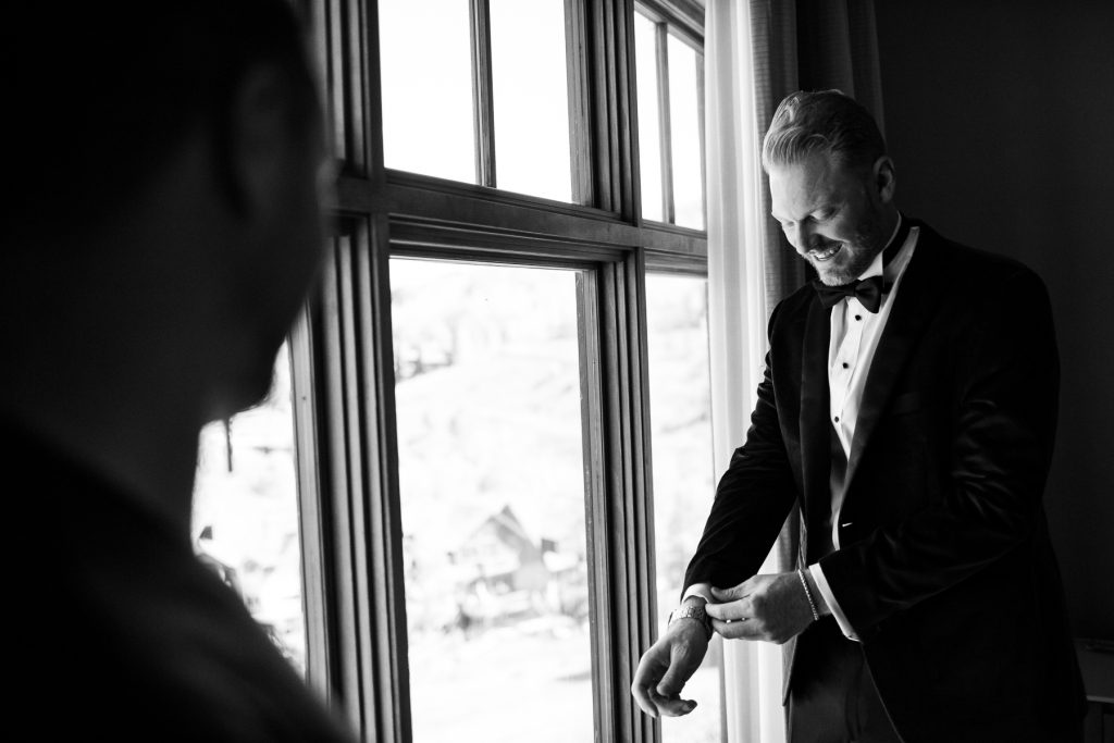 A groom gets ready for his Aspen elopement in a hotel.