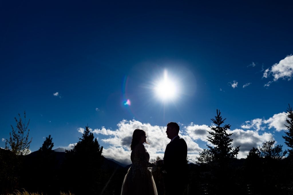 A silhouette of a couple exchanging vows in the mountains of colorado.