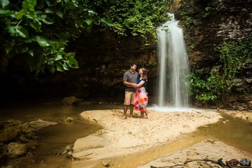 A couple is photographed under a waterfall in Bali by professional elopement photographer Lucy Schultz.