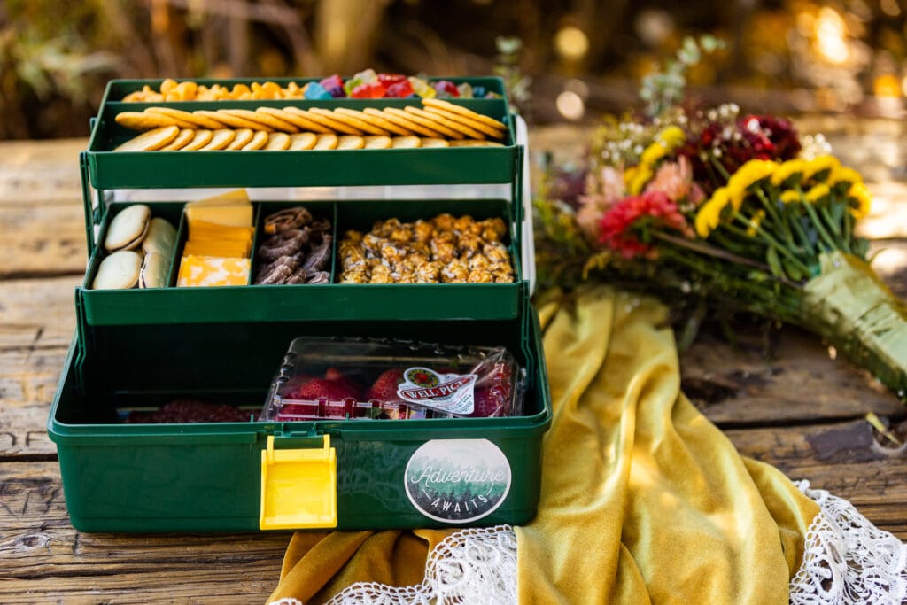An elopement picnic Snackle Box is a tackle box filled with snacks.