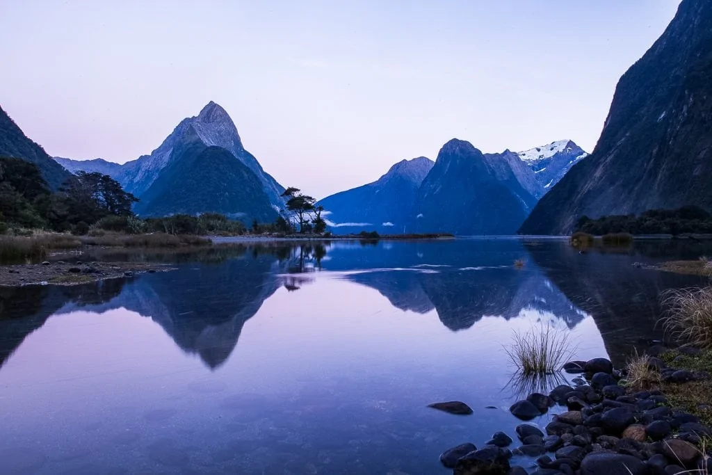 A photo of Mitre Peak at sunrise reflected in Milford Sound, New Zealand.