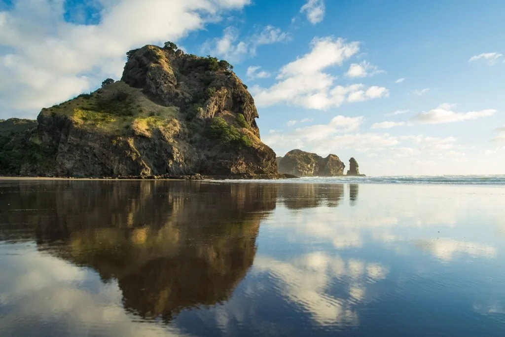 A reflection of Lion rock at Piha, North Island New Zealand