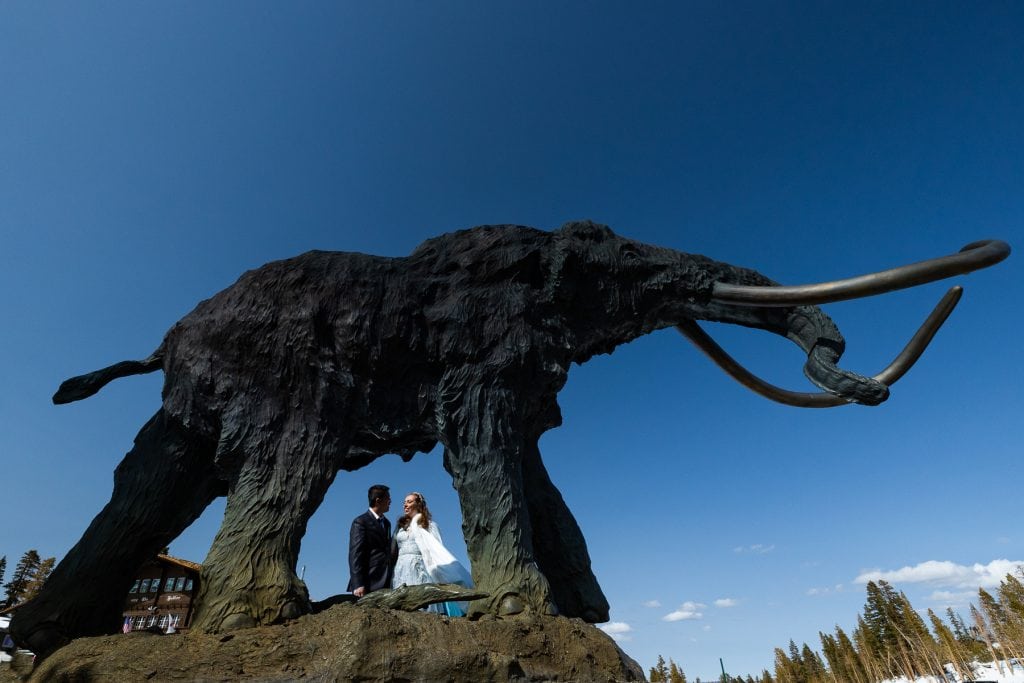 A couple is framed by the legs of a Mammoth statue in Mammoth, California