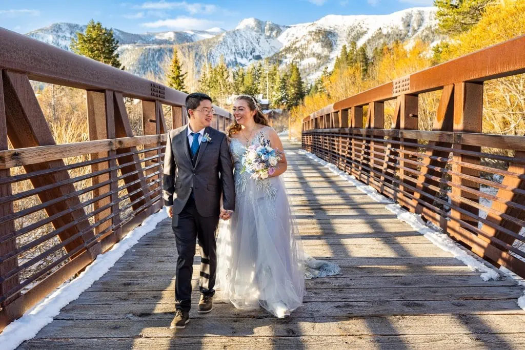 A wedding couple strolls across a bridge in California.