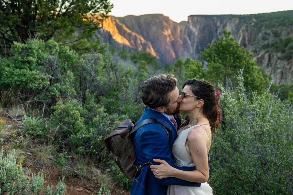 A just married couple smooches in front of Black Canyon of the Gunnison.