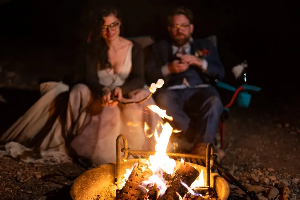 A camping elopement with the newlyweds roasting marshmallows.