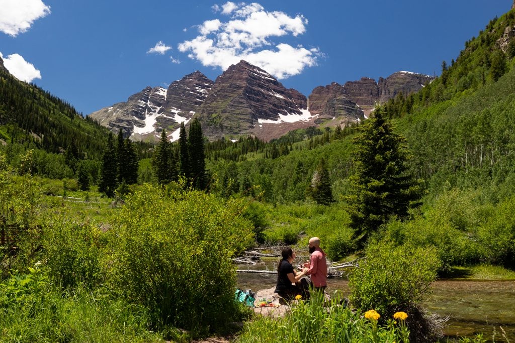 A candid photo of a romantic surprise proposal at the Maroon Bells.