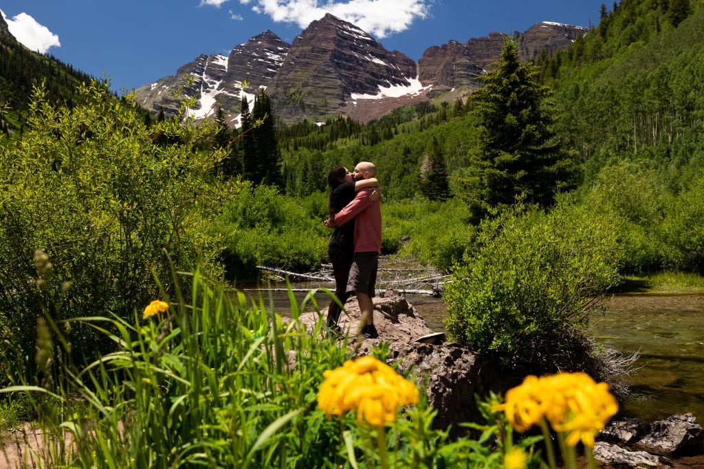 A couple kiss after getting engaged at the Maroon Bells.