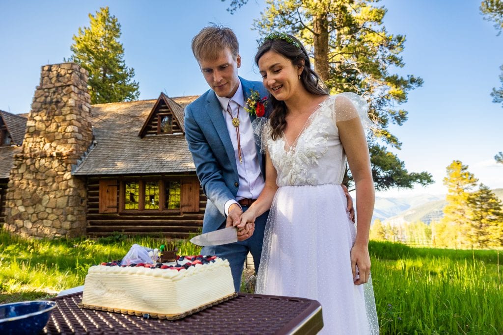An elopement couple cuts the cake at the Tigiwon Community House in Vail, Colorado.