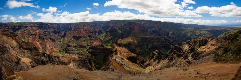 A panoramic image of Waimea Canyon state park in central Kauai on a sunny day.