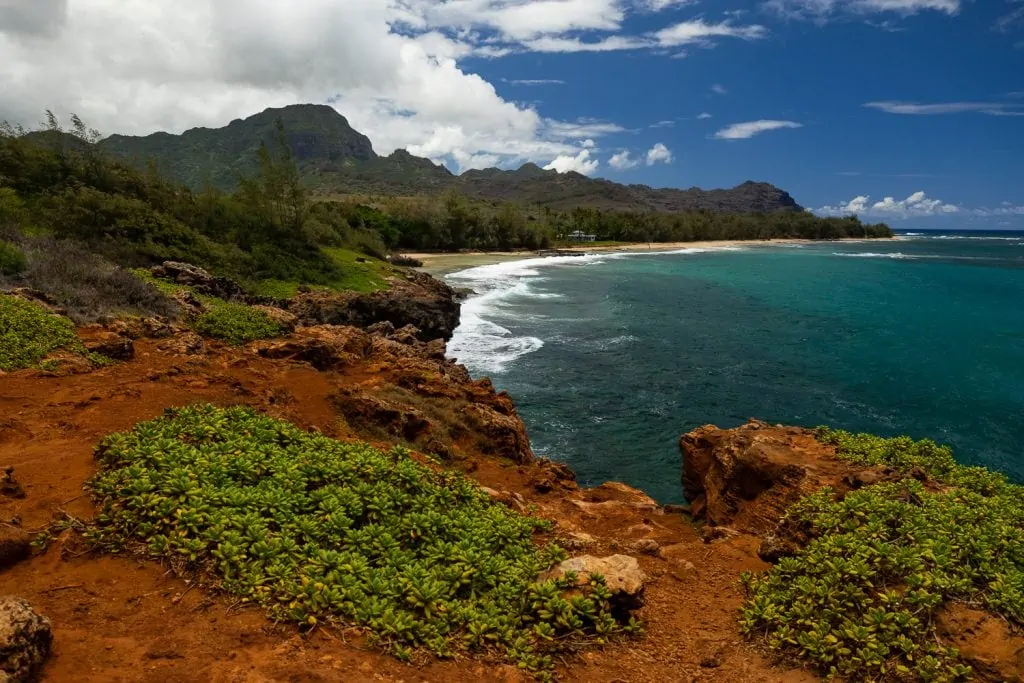 A red rocky cliff elopement location on Kauai's south shore.