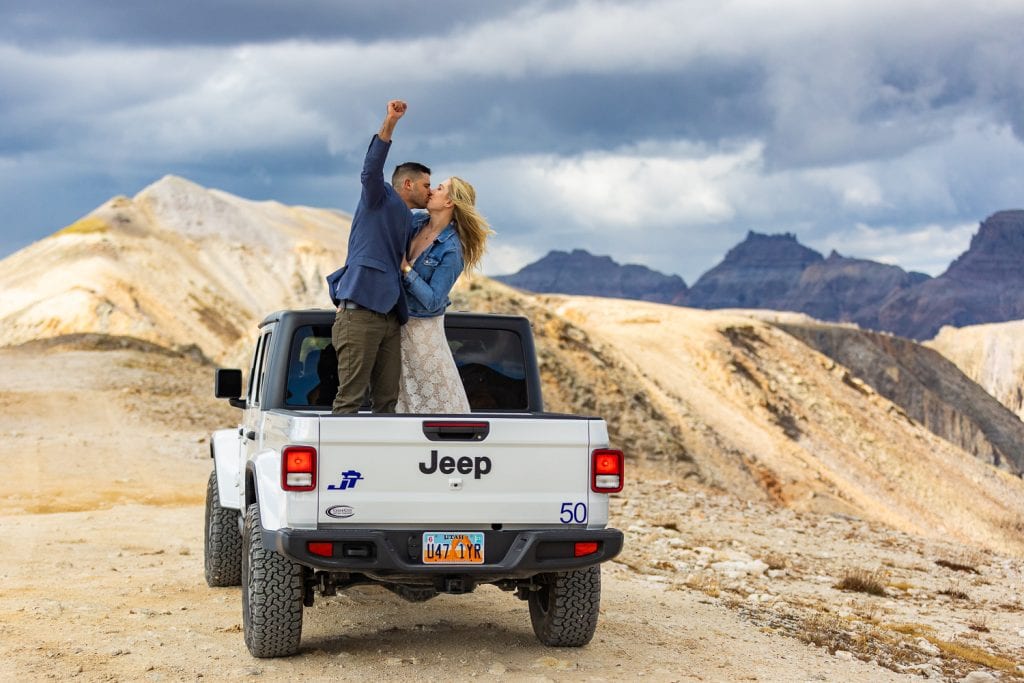 A couple stands in the back of a jeep at imogene pass, telluride.