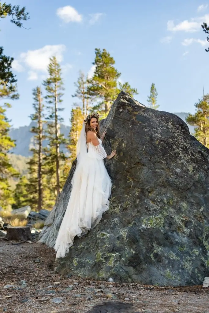 A rock climbing bride in Yosemite National Park poses on a rock on her elopement day.