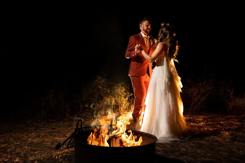 A wedding first dance by campfire light.