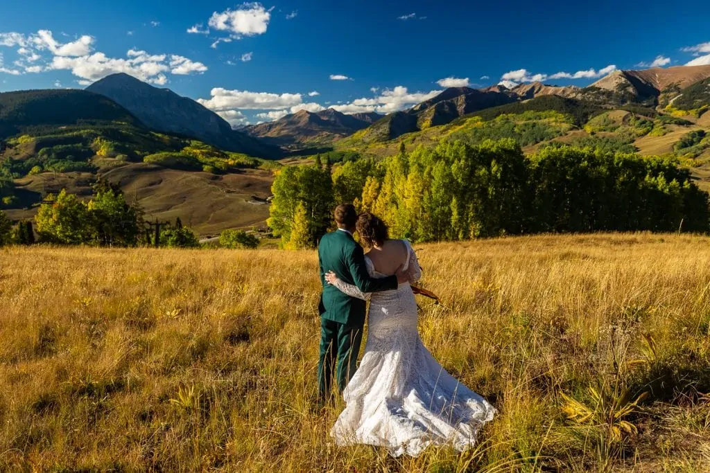 An elopement couple looks at a huge mountain view in Crested Butte, Colorado.