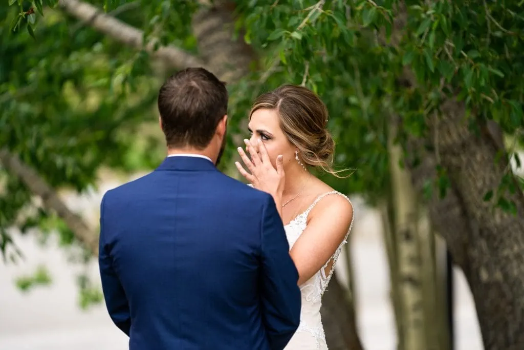 An emotional bride wipes away a tear while hearing her husbands elopement vows.