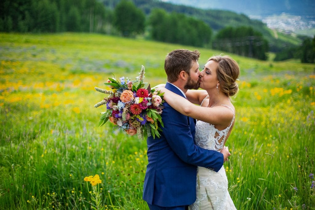 An elopement couple kiss in the wildflowers in Crested Butte, Colorado.