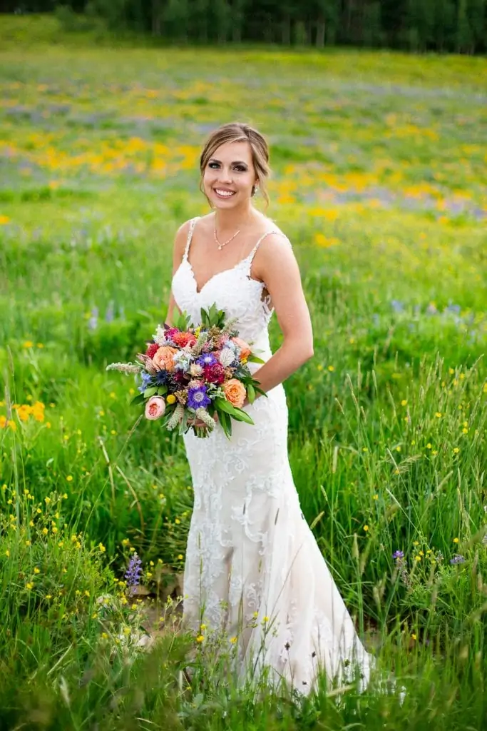 A bride stands in a field of wildflowers in Crested Butte, Colorado.