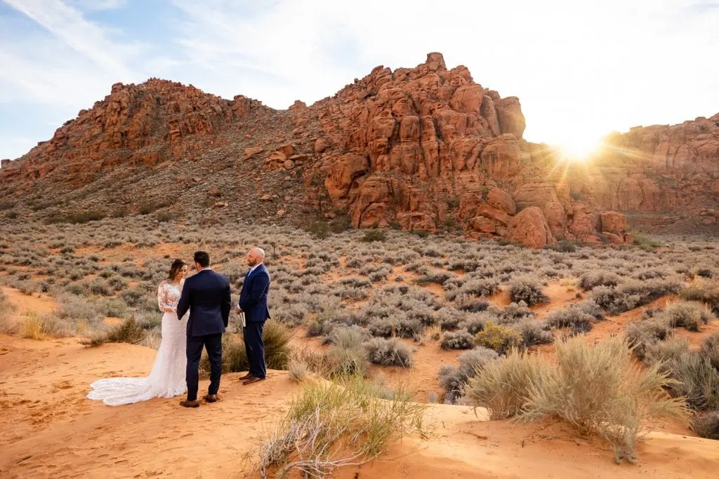 A bride and groom getting married in Snow Canyon, utah at sunset.
