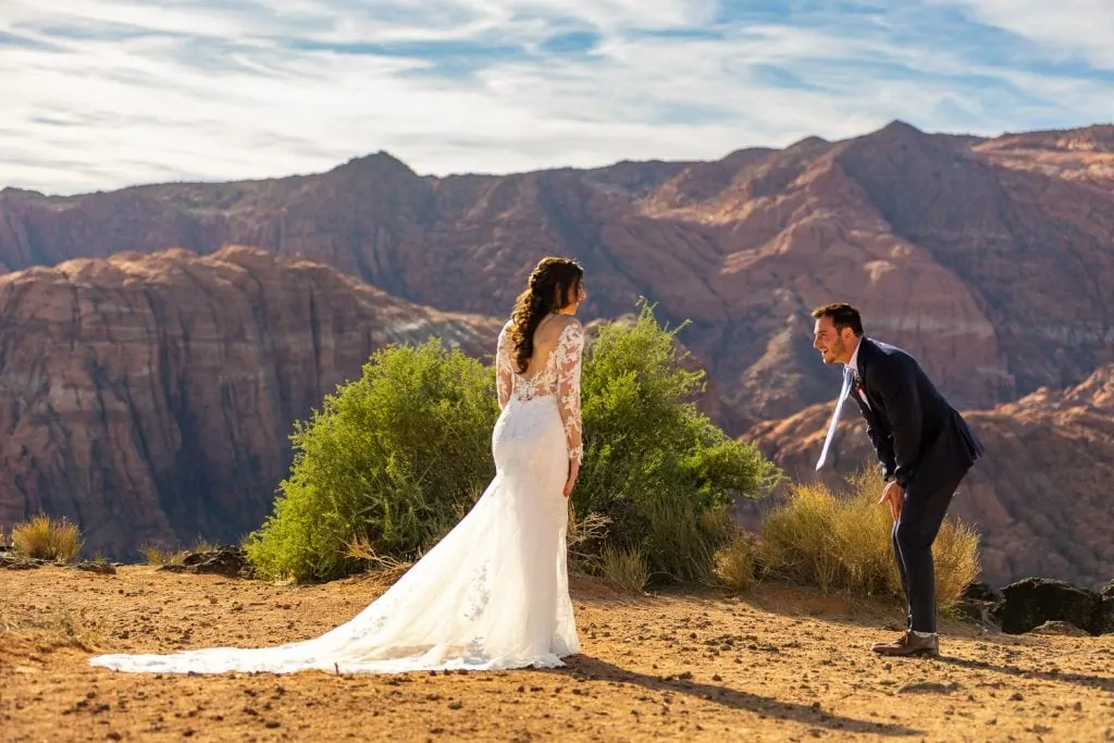 A first look at Snow canyon state park in Utah where the groom is doubled over.