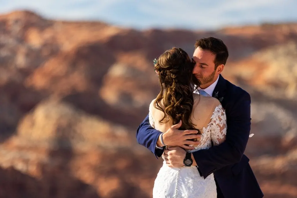 A bride and groom embrace in the desert on their elopement in Sedona.