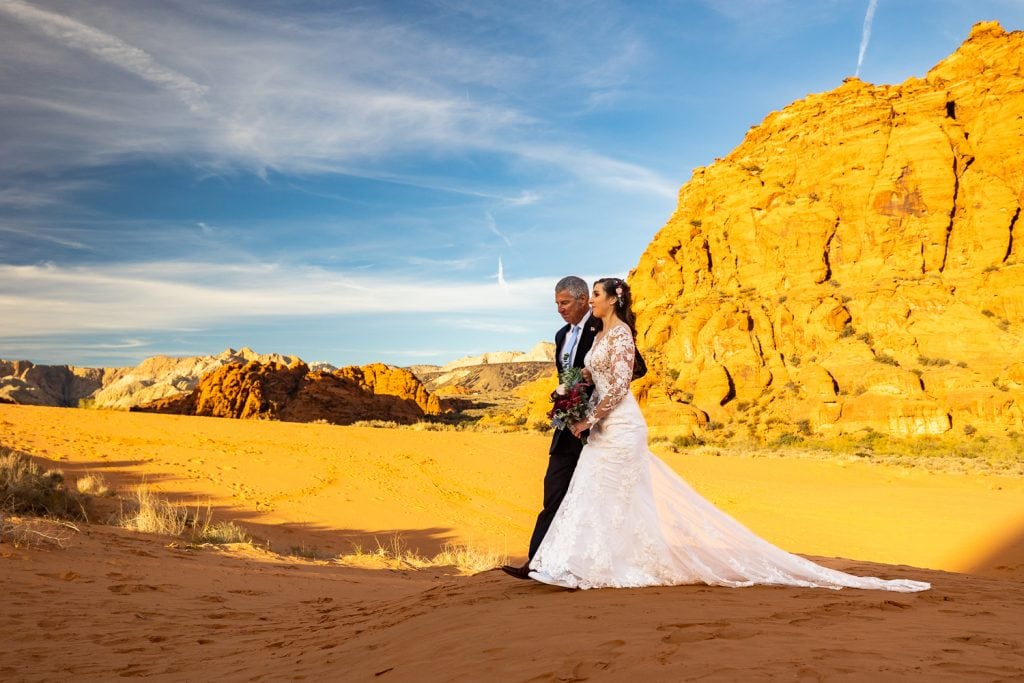A bride walks up to her Elopement ceremony at the Sand Dunes in Snow Canyon state park.