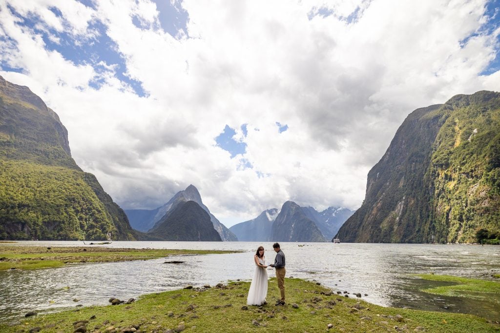 The elopement couple unwraps a gift from family friends during their private elopement in Milford Sound, New Zealand.